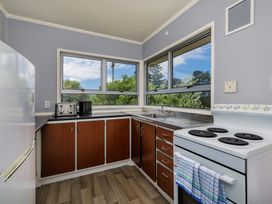 A kitchen with a refrigerator, sink, and stove at Te Tiriti Beach House - Paihia