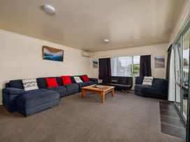 A living room with a sofa and coffee table at Te Tiriti Beach House - Paihia Holiday Home