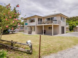 A house with a balcony and garden at Te Tiriti Beach House - Paihia Holiday Home Paihia