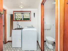 A laundry room with a washing machine and a sink at Dream View Waterfront - Paihia Holiday Home, Paihia