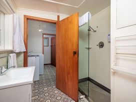 A bathroom with a shower and a washing machine at Dream View Waterfront - Paihia Holiday Home