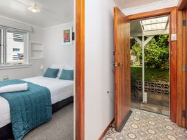 A bedroom with a bed and window at Dream View Waterfront - Paihia Holiday Home in Paihia