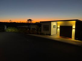A house with garage and driveway at Sunset Stay - Raglan Holiday Home Raglan