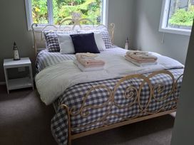 A bedroom with a bed and nightstand at The Lighthouse - Te Mata Holiday Home