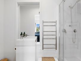 A bathroom with a double sink vanity a glass shower enclosure and a wall-mounted towel rack at Okere Retreat - Lake Rotoiti Getaway Lake Rotoiti