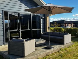 An outdoor seating area with a sofa and coffee table at Mountainview Escape - Te Anau