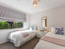 A bedroom with two single beds a dresser with lamps and a mirror at Tahunanui Shoreside - Nelson Holiday Home in Tahunanui Beach