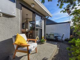 An outdoor seating area with a table and chairs at Tahunanui Shoreside - Nelson Holiday Home Tahunanui Beach