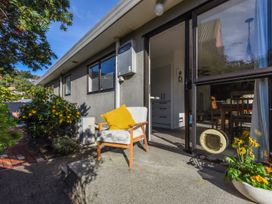 An outdoor area with a chair and plants at Tahunanui Shoreside - Nelson Holiday Home Tahunanui Beach
