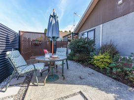 A garden area with a table and chairs at Tahunanui Shoreside - Nelson Holiday Home, Tahunanui Beach