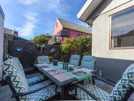 An outdoor patio with a table and chairs at Tahunanui Shoreside - Nelson Holiday Home Tahunanui Beach