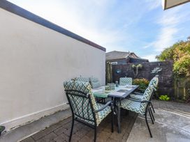 An outdoor dining area with a table and chairs at Tahunanui Shoreside - Nelson Holiday Home Tahunanui Beach