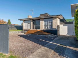 A front yard with gravel and a wooden step entrance to a brick house at King's Crossing - Your Taupo Getaway in Taupo Central