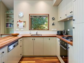 A kitchen with wooden countertops white cabinets a window over the sink and appliances at Peaceful Outlook - Hatepe Holiday Home in Hatepe