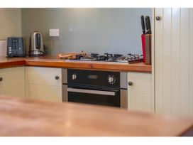A kitchen countertop with a gas stove oven toaster electric kettle and knife block at Peaceful Outlook - Hatepe Holiday Home in Hatepe