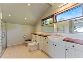 A bathroom with a sink a bidet a toilet shower area and towel rack at Peaceful Outlook - Hatepe Holiday Home in Hatepe