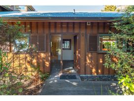 The entrance to a wooden house with plants on either side and a path leading to the door at Peaceful Outlook - Hatepe Holiday Home in Hatepe