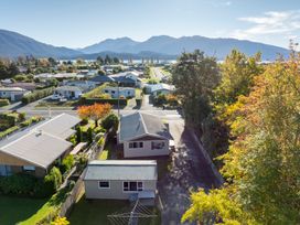 A residential neighborhood with houses trees and mountains in the background at Relaxing Kiwi Bach - Te Anau Holiday Home in Te Anau