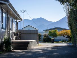 A residential area with houses trees and mountains in the background at Relaxing Kiwi Bach - Te Anau Holiday Home in Te Anau