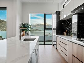 A kitchen with a marble countertop sink and black marble backsplash with mountain view at Remarkable QT  - Queenstown Holiday Home in Queenstown