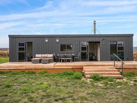 A modern small house with a wooden deck patio and outdoor furniture at Alex Vineyard - Alexandra Holiday Home in Alexandra