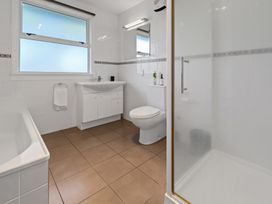 A bathroom with a bathtub sink toilet and shower at Bell Cottage - Oakura Holiday Home in Oakura