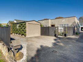 An exterior view of a house with a garage and a fenced yard at Coastal Charm  Napier Holiday Home in Napier