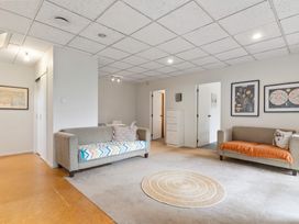 A living room with two sofas and a round rug on the floor at Waiake Family Retreat Auckland