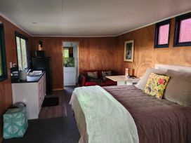 A studio with a bed and couch at Tui Cottage - Waipu Holiday Retreat, Waipu