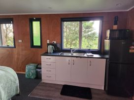A kitchen with a sink and appliances at Tui Cottage - Waipu Holiday Retreat Waipu