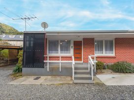 A brick holiday home exterior with a wooden door steps and railings at Picton Central Picton Holiday Home in Picton