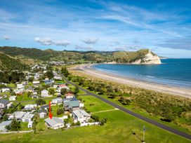 An aerial view of a beach and houses at Mahia Bliss - Surf & Serenity Holiday Home Mahia Peninsula
