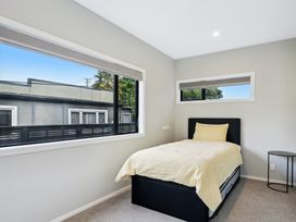 A bedroom with a single bed and window at Seabreeze Retreat - Paraparaumu Beach