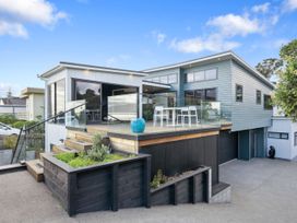 A house with a deck and garden at Seabreeze Retreat - Paraparaumu Beach