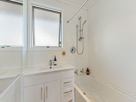 A bathroom with a sink and a bath tub at The Bay Breeze Retreat - Two Mile Bay