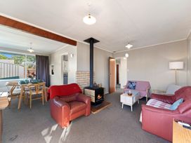 A living room with a fireplace and dining table at The Bay Breeze Retreat - Two Mile Bay