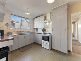 A kitchen with cabinets and an oven at The Bay Breeze Retreat - Two Mile Bay