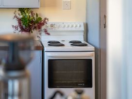 A stove with a flower vase on the counter at The Bay Breeze Retreat - Two Mile Bay