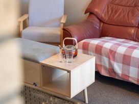 A living room with a wooden table, glasses, and a tea pot at The Bay Breeze Retreat - Two Mile Bay