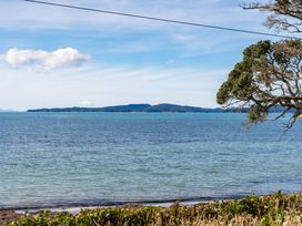 A view of the water and distant island at Heron's Hideaway - Snells Beach