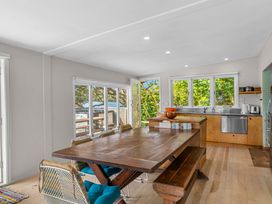 A dining room with a table and kitchen area at Heron's Hideaway - Snells Beach