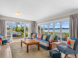 A living room with a sofa and coffee table at Heron's Hideaway - Snells Beach