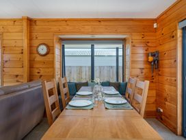 A dining room with a table set for meals at Seabreeze Surf House - Whitianga Escape