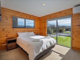 A bedroom with a bed and window at Seabreeze Surf House - Whitianga Escape