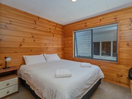 A bedroom with a bed and window at Seabreeze Surf House - Whitianga