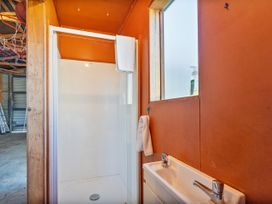 A bathroom with a shower and sink at Seabreeze Surf House - Whitianga