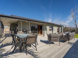 An outdoor seating area with a table and chairs at Seabreeze Surf House - Whitianga