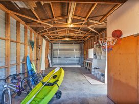 A garage with bicycles and a kayak at Seabreeze Surf House - Whitianga