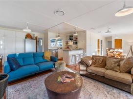 A living room with a blue sofa and coffee table at Waterside Bliss - Taupo Holiday Home Taupo Central
