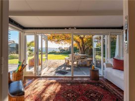 A conservatory with a view of a garden at Waterside Bliss - Taupo Holiday Home, Taupo Central